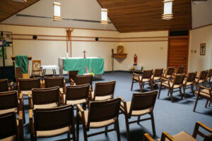 Inside St. Charles Retreat Centre, a chapel with chairs arranged around a green altar.