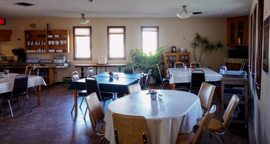 Main dining room at St. Charles Retreat Centre, featuring tables and chairs arranged for meals during retreats.
