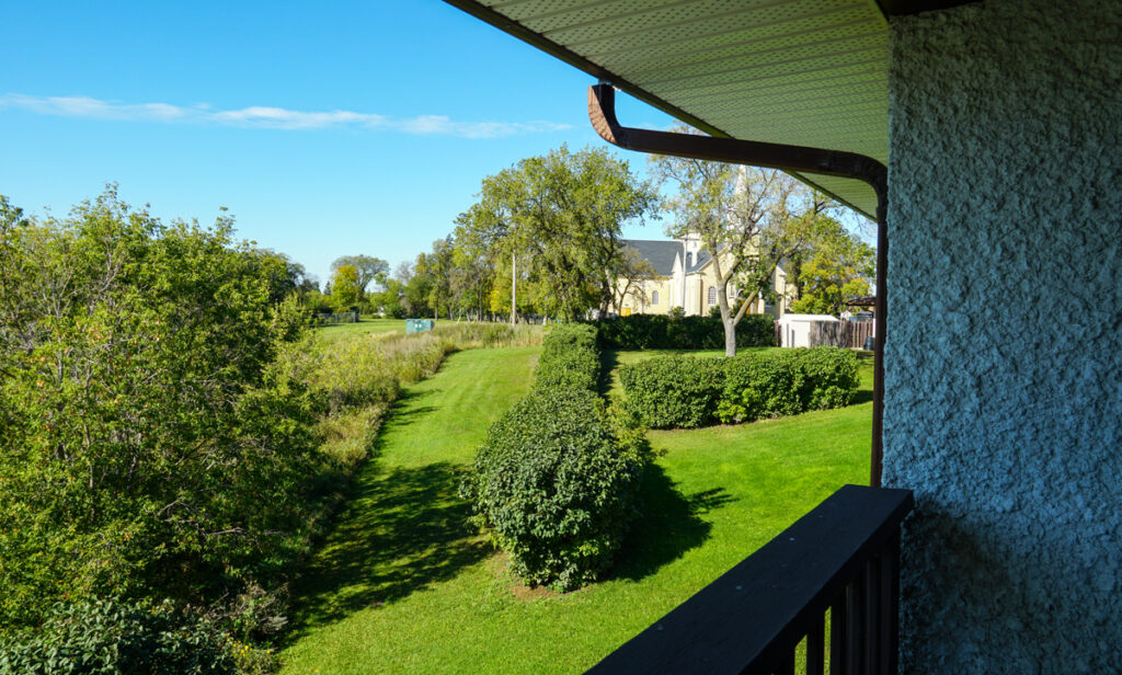 A view from the balcony at St. Charles Retreat Centre, overlooking the riverbank, trees, and lush greenery.